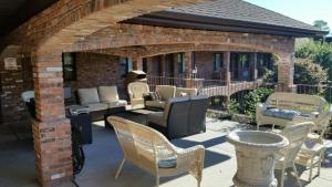 a patio with chairs and tables and a brick building at Chalet Inn & Suites in Centerport