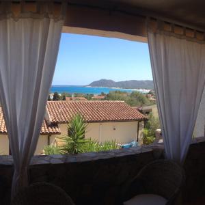サンタ・ルチアにあるVilla Relaxのカーテン付きのバルコニーから海の景色を望めます。