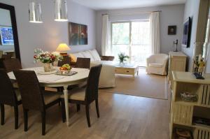 a living room with a table and chairs and a living room at Apartament Rezydencja Bryza Jurata in Jurata