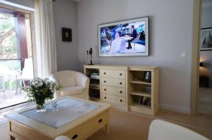 a living room with a tv on a wall at Apartament Rezydencja Bryza Jurata in Jurata