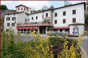 un grand bâtiment blanc avec des fleurs jaunes devant lui dans l'établissement Hôtel Restaurant Le Pain de Sucre, à Monistrol-dʼAllier