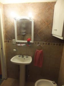 y baño con lavabo, espejo y aseo. en Great Loft Nunez en Buenos Aires