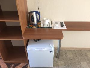 a desk with a coffee maker on top of a refrigerator at Iceberg in Pizunda