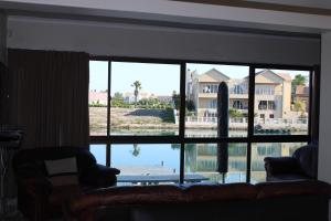 a living room with a large window looking out at the water at The Port Owen Holiday House in Velddrif