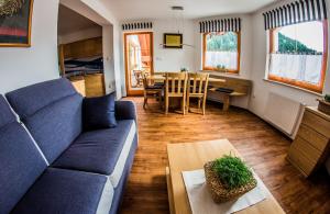 a living room with a blue couch and a table at Apartments BBI in Luče