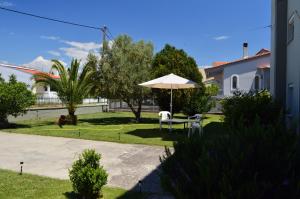 a patio with an umbrella and a table and chairs at Politakis Apartment in Keramoti