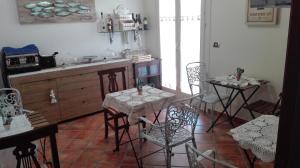 ポルトパーロにあるB&B Terra del Soleのキッチン(テーブル2台、椅子、シンク付)