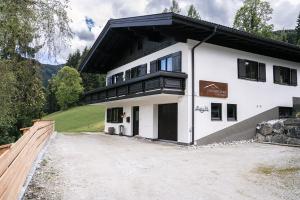 a large white building with a black roof at Steinberghaus Ferienhaus in Leogang
