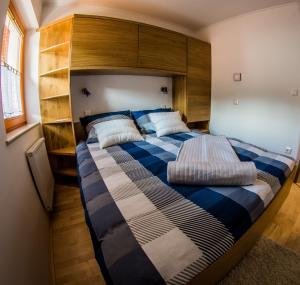 a bedroom with a large bed with a wooden headboard at Apartments BBI in Luče