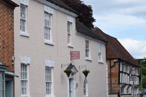 a white building with white windows on a street at Fosbroke Cottage in Bidford