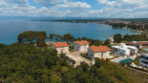 an aerial view of a house on a hill next to the water at Mare & Mons Seafront Apartments in Malinska