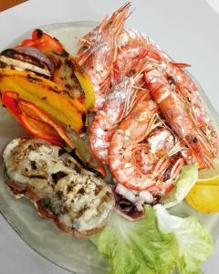 a plate of food with shrimp and other seafood at Sonnellino in Maremma in Massa Marittima +66 photos