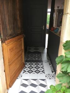 aoyer with a door and a black and white tile floor at L'ANNEXE in Carennac