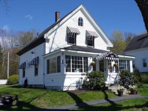 a white house with an awning on it at Starlight Lodge at Rockport Harbor in Rockport