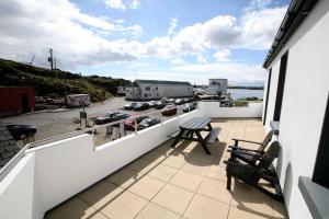 a balcony with two benches and a view of a parking lot at Harbour front apartments in Burtonport