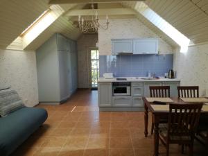 a kitchen with a table and a dining room at Namelis prie marių in Nida