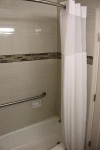 a bathroom with a shower with a white shower curtain at Bay Bridge Inn San Francisco in San Francisco