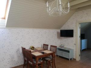 a dining room with a table and chairs and a chandelier at Namelis prie marių in Nida