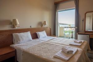 a bedroom with a large bed with towels on it at Apollon Hotel in Ancient Epidauros