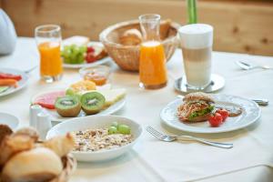 uma mesa coberta com pratos de alimentos e bebidas em Après Post Hotel em Stuben am Arlberg