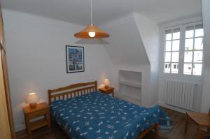 a bedroom with a bed with a blue comforter at Appartement Solidor Vue Mer in Saint Malo