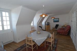 a dining room and living room with a table and chairs at Appartement Solidor Vue Mer in Saint Malo