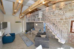ein Wohnzimmer mit einer Steinmauer und einer Treppe in der Unterkunft Palazzo Max and Alex Apartments in Kotor