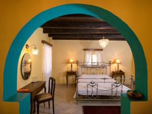 a bedroom with a bed and a table and a desk at Villa De Loulia in Peroulades