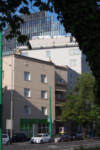 wysoki budynek z zaparkowanymi przed nim samochodami w obiekcie Szczęśliwa 13 w Poznaniu