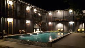 a swimming pool in front of a building at night at Na-tub Hostel in Ban Tai