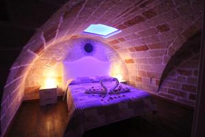 een paarse kamer met een bed in een bakstenen muur bij Dimora Nonna Catarì in Polignano a Mare