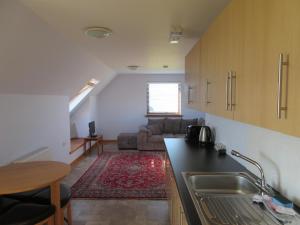 cocina y sala de estar con sofá y mesa en Taighali Apartment, en Aultbea