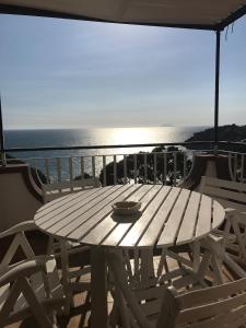 a wooden table and chairs on a balcony with the ocean at La Terrazza Sul Mare in Gaeta