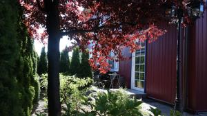 a red house with a tree in front of it at Harmony Park Nida House in Nida