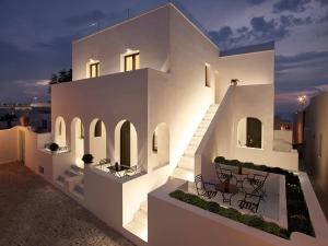 a white house with lights on the side of it at The Arches in Oia