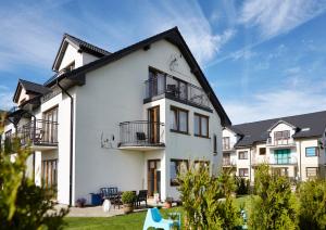una casa bianca con balconi e cortile di Sunrise Apartamenty a Łeba