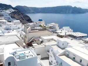 an aerial view of white buildings and the ocean at The Arches in Oia