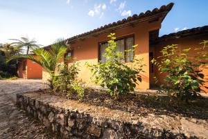 a house with a stone wall in front of it at Hotel Taselotzin in Cuetzalán del Progreso