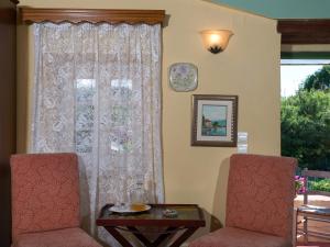 a room with two chairs and a table and a window at Villa De Loulia in Peroulades