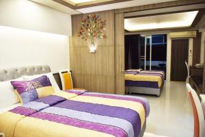 a bedroom with two beds with purple and yellow at Family Suite Room Pratunam in Bangkok