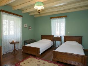 a bedroom with two beds and a chandelier at Villa De Loulia in Peroulades