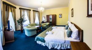 チェスキー・クルムロフにあるホテル ドヴォラック チェスキー クルムロフのベッドとリビングルームが備わるホテルルームです。