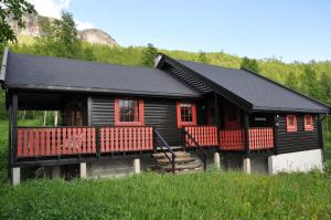 a log cabin with red windows and a black roof at Liseth Pensjonat og Hyttetun in Garden