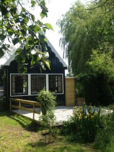 a small house with a black and white facade at B&B Saense huisje in Assendelft