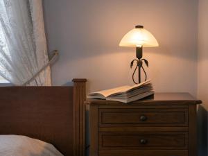a lamp on a dresser with a book on it at Villa De Loulia in Peroulades