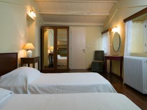 a hotel room with two beds and a bedroom at Villa De Loulia in Peroulades