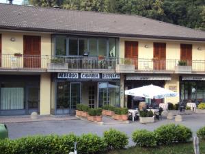 a hotel with an umbrella in front of it at Hotel Cavaria in San Fedele Intelvi