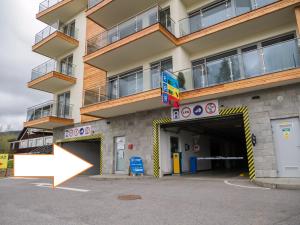 un edificio con una flecha apuntando a un estacionamiento en Apartmán Cyril A 104, en Starý Smokovec
