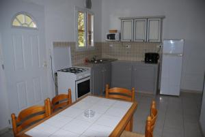 a kitchen with a table and a stove and a sink at Residence Ribellinu in Pianottoli-Caldarello