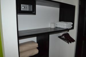 a room with a shelf with towels and a microwave at Hotel Secreto La Fortuna in Fortuna